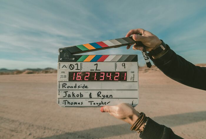 Film clapperboard on a desert set, representing the theme of false advertisements in media productions.