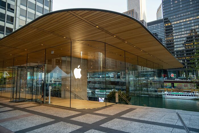Glass-fronted store with an Apple logo, representing company advertising.