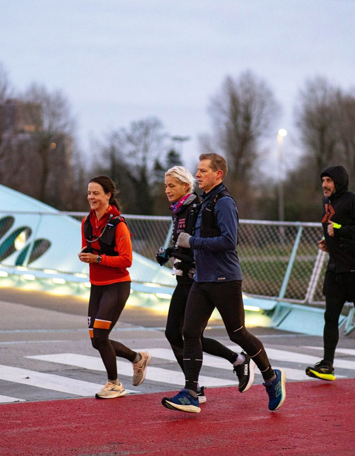 55YO woman sets world record running a marathon, jogging with a group on a bridge. 55YO woman sets world record running a marathon, jogging with a group on a bridge.
