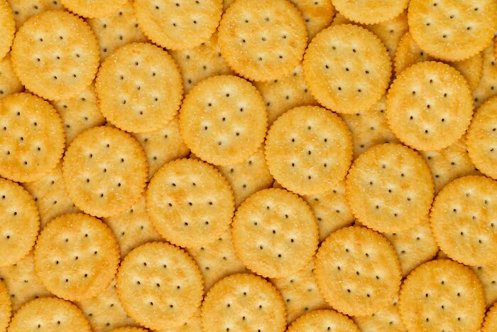 "Round crackers overlapping, texture background, light golden color, pattern design."