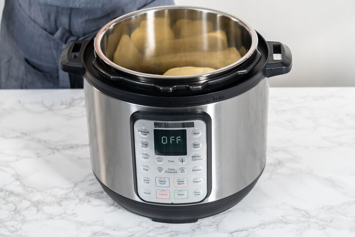 Electric pressure cooker on a marble countertop, a popular money-saving kitchen purchase.