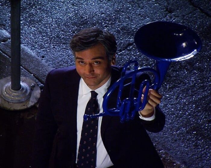 Man holding a blue French horn, symbolizing TV shows that disappointed their fans.