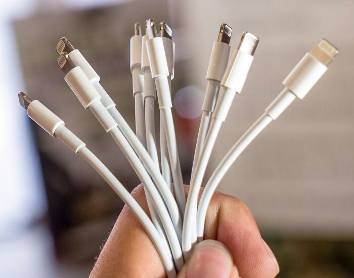 Affordable white charging cables held in a hand, illustrating items that make life easier.