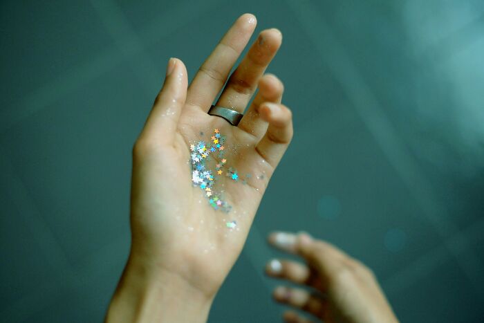 Hand holding colorful star-shaped glitter.