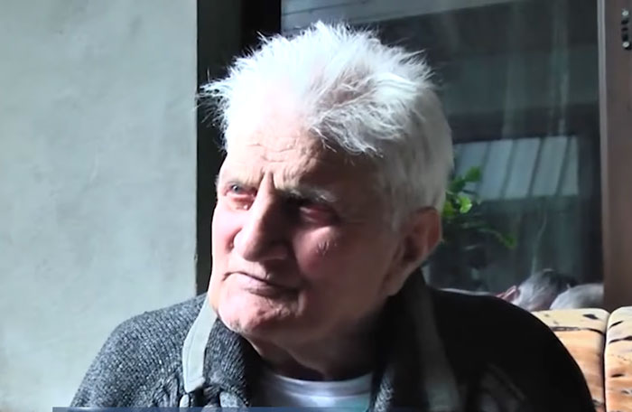 Elderly man gazing pensively indoors, linked to mystery disappearance and missing person case.