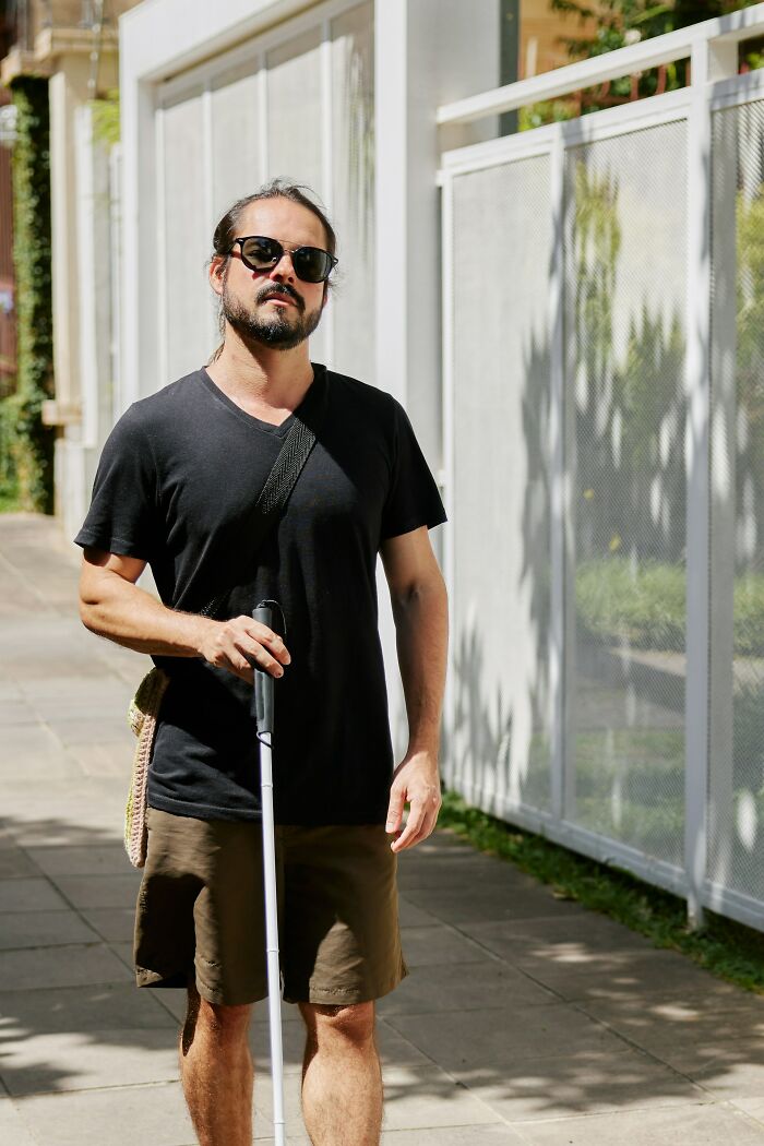 Man walking with a cane in a casual urban setting, related to reasons for significant weight gain.
