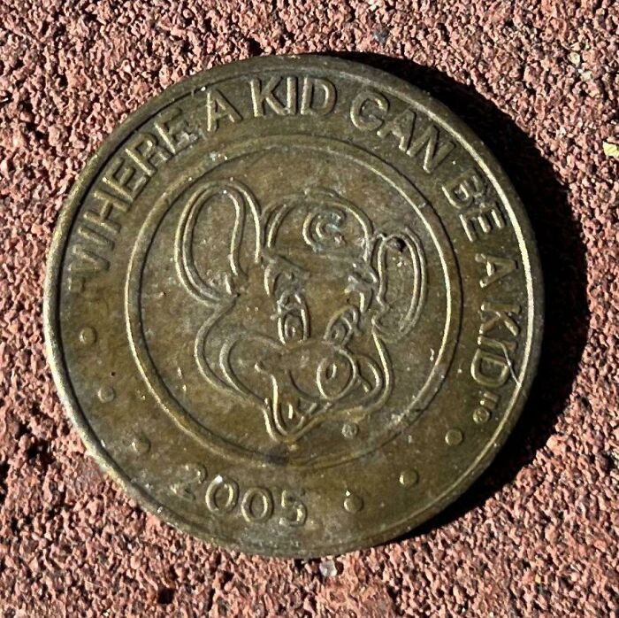 Coin with mouse engraving, dated 2005, on textured surface, intriguing numismatists worldwide.