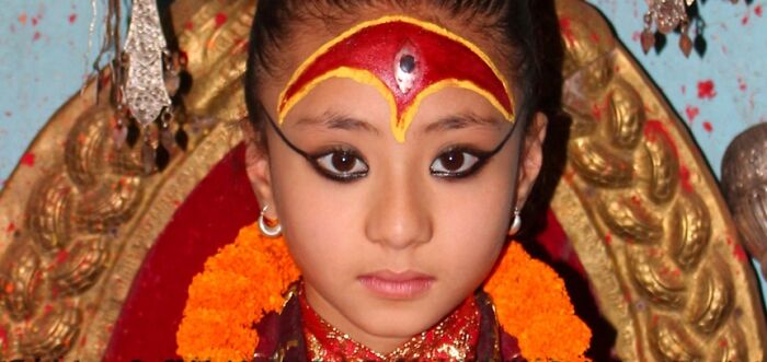 Child dressed as a living goddess, showcasing a normal cultural tradition in Nepal.