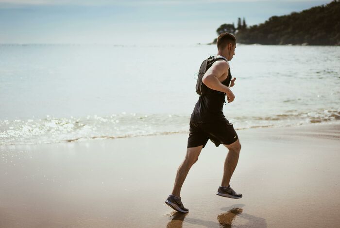 A person jogging on a beach, embodying weight-loss tips like fun walks and exercise for shedding pounds.