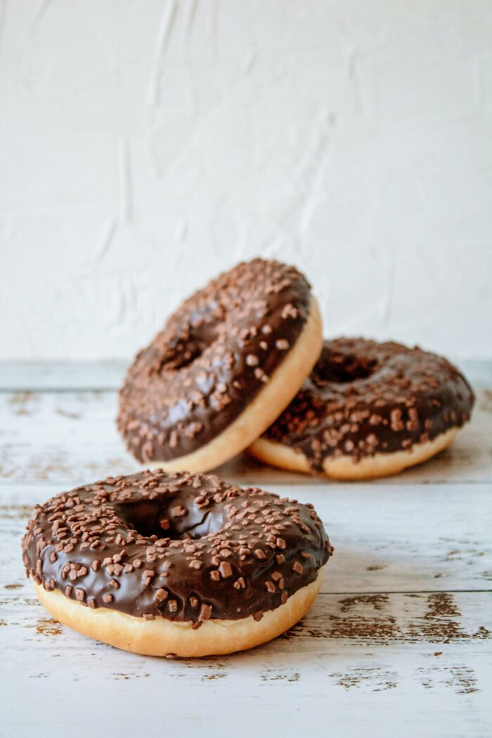 Chocolate donuts on a rustic wooden surface, illustrating a lifetime supply of sweet treats experience.