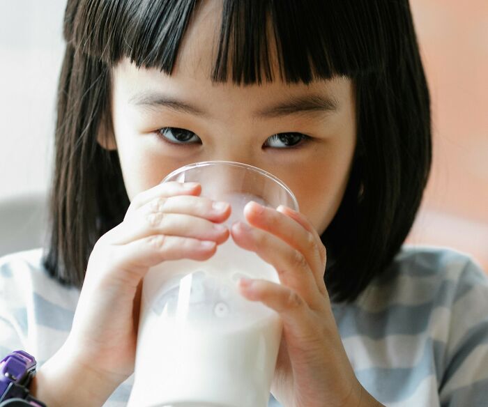 Child drinking milk, representing millennials struggling with adulthood.