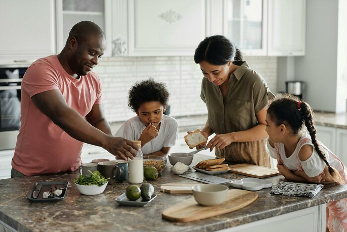 Family preparing a meal together in the kitchen, applying smart household budget techniques.