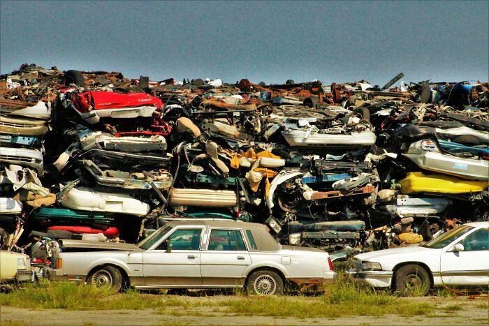 A large pile of scrapped cars, illustrating outdated financial stereotypes in automotive culture.
