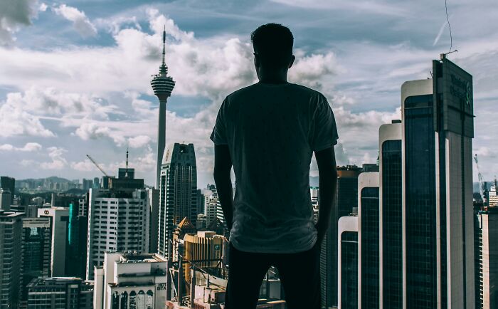 Silhouette of a person overlooking a city skyline, exemplifying outdated financial stereotypes with urban backdrop.