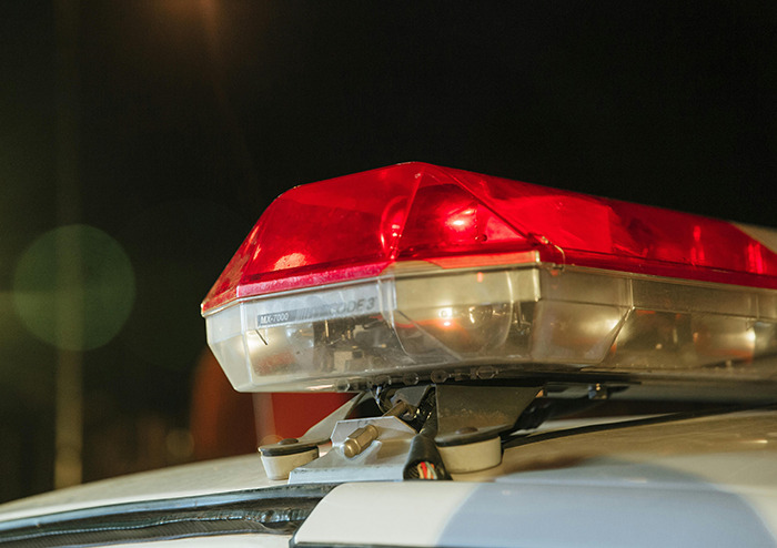 Police car with flashing lights at night, related to missing woman found after 52 years.