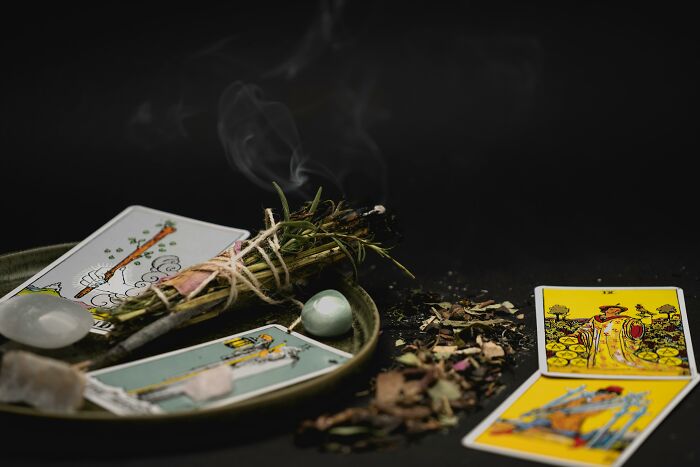 Tarot cards and sage on a dark background.