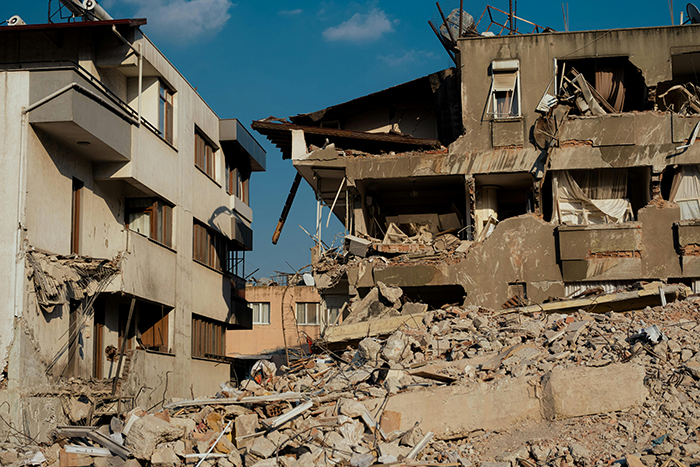 Collapsed buildings after an earthquake, highlighting disaster prediction challenges.