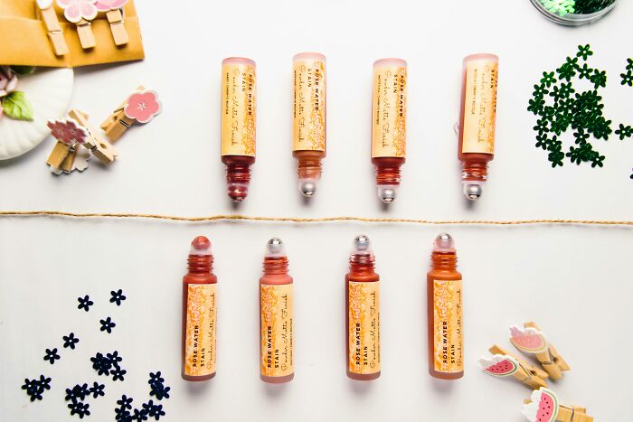 Roll-on perfume bottles arranged in two rows, showcasing the star behind the brand concept, amid decorative items. Roll-on perfume bottles arranged in two rows, showcasing the star behind the brand concept, amid decorative items.