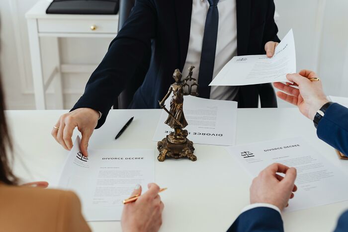 People exchanging documents with a statue on the table, representing life improvements through purchases.