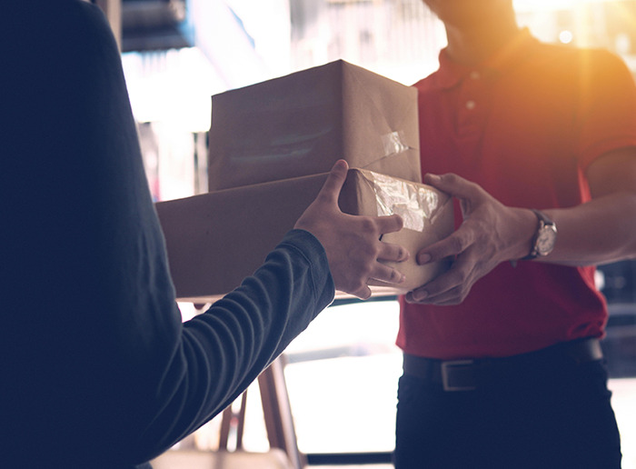 Mailman handing a package to a person.. Mailman handing a package to a person..