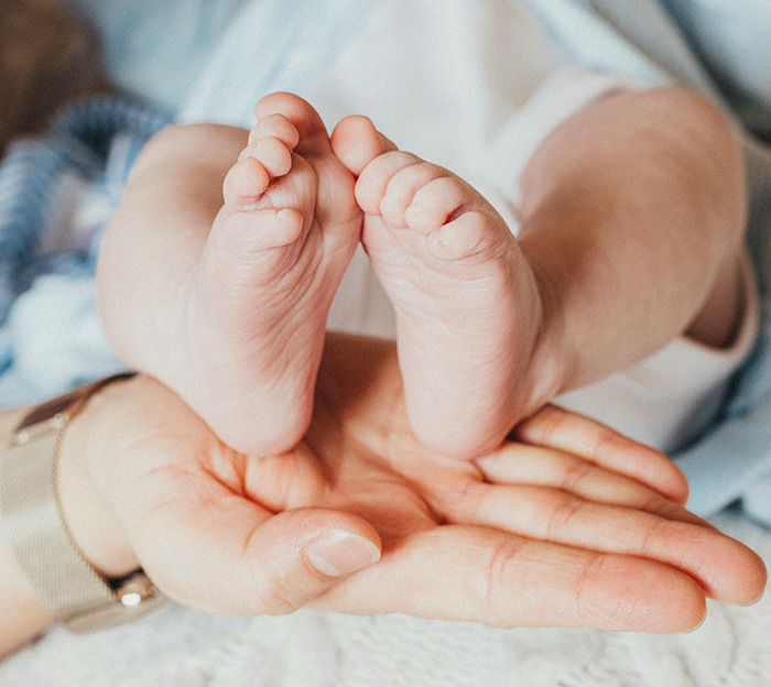 Person holding a baby's feet. Person holding a baby's feet.