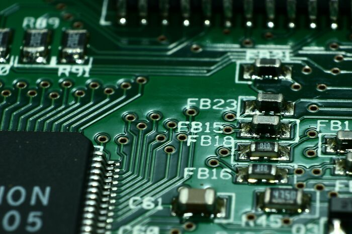 Close-up of a green circuit board, illustrating how everyday electronics might seem harmless but pose hidden dangers.