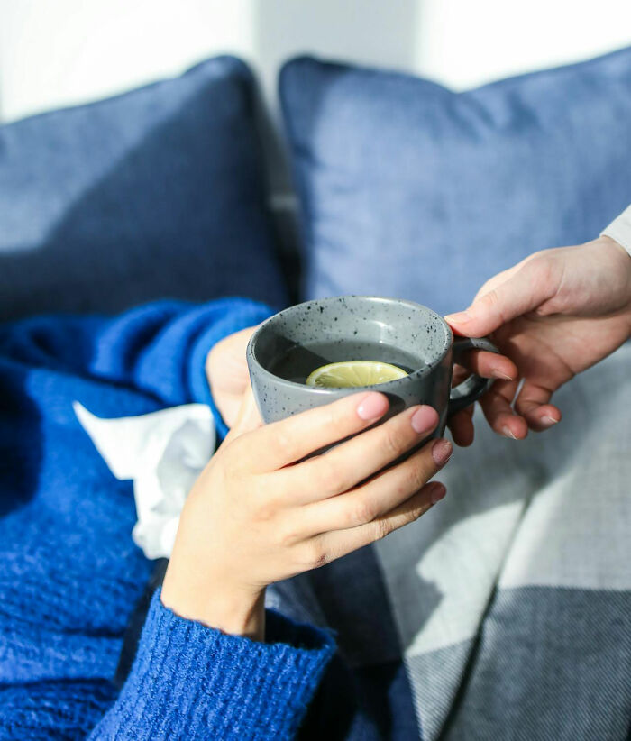 Handing a mug of lemon tea, showcasing non-s****l gestures that can turn women on.