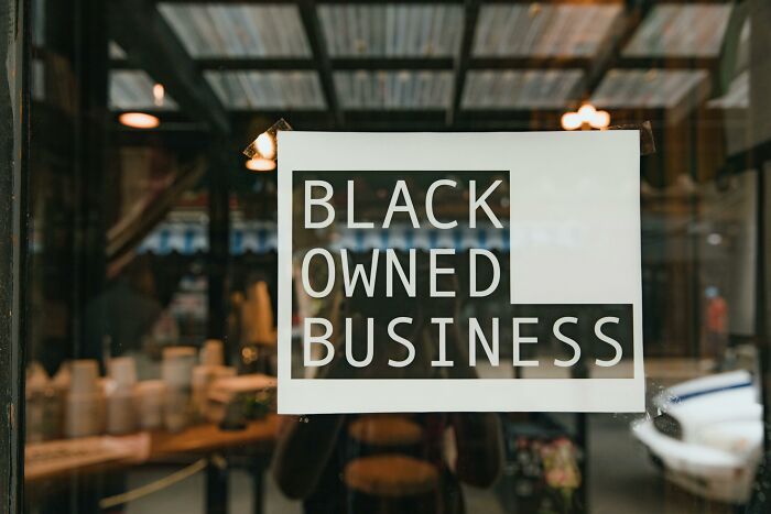Sign in a storefront window reading "Black Owned Business".