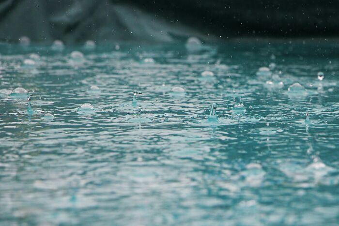 Raindrops on a surface, capturing the essence of weird unsolved mysteries through the lens of nature's phenomena.