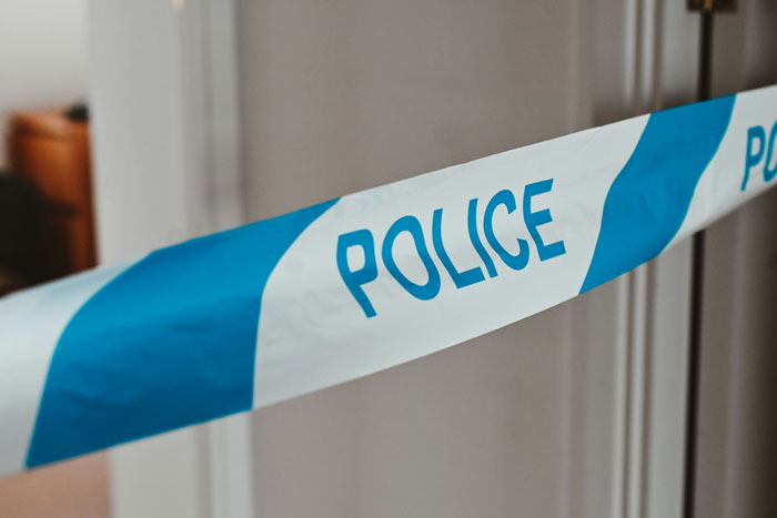 Police tape at a crime scene related to a family incident involving arranged marriage and malnourishment issues.