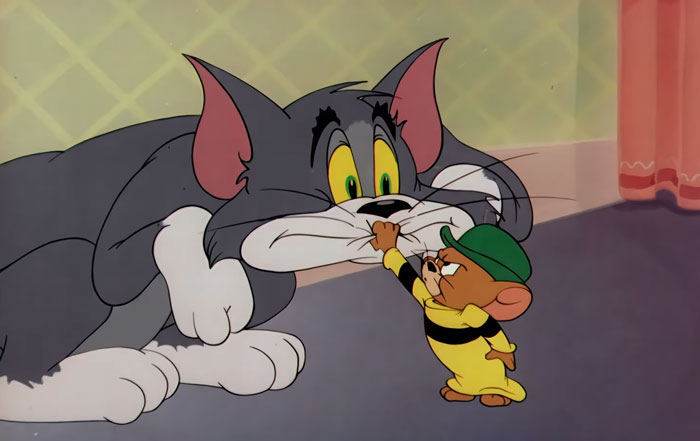 Cartoon characters Tom and Jerry, with Tom looking surprised as Jerry stands confidently, conveying a sense of conflict. Cartoon characters Tom and Jerry, with Tom looking surprised as Jerry stands confidently, conveying a sense of conflict.