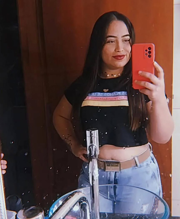 Joyce Sousa Ara&uacute;jo taking a mirror selfie, wearing a black shirt and jeans.
