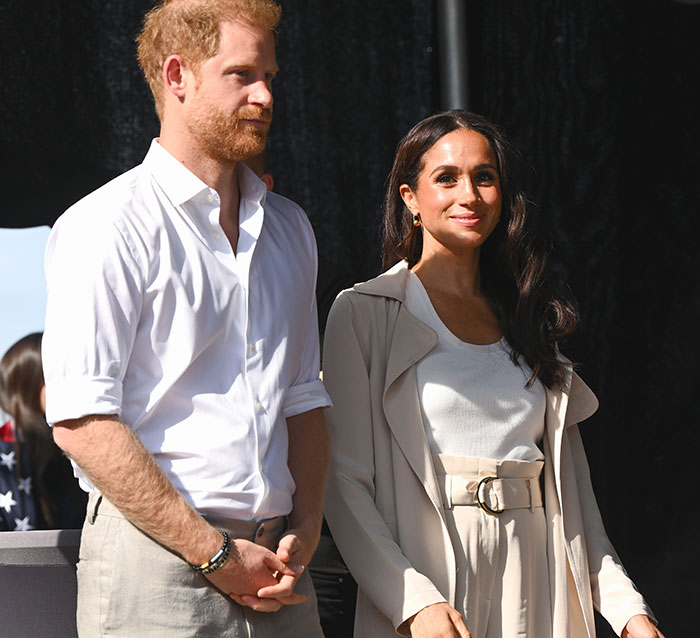Prince Harry and Meghan Markle standing outdoors, engaging with LA fire victims.