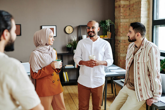 People having a lively discussion in a modern office setting, illustrating psychological tricks in communication.