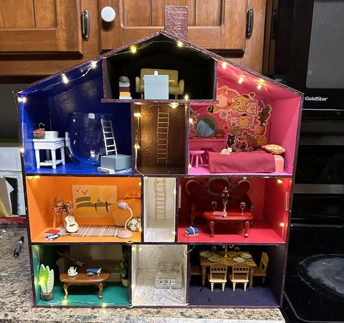 Miniature replica of a famous house with colorful, furnished rooms and string lights, crafted as a thoughtful gift. Miniature replica of a famous house with colorful, furnished rooms and string lights, crafted as a thoughtful gift.