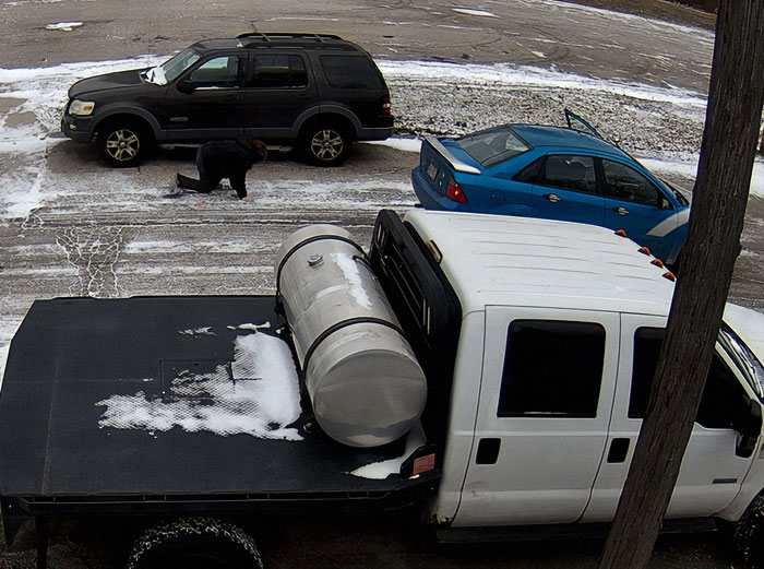 A scene involving road rage in a snowy parking lot with parked vehicles and a person on the ground. A scene involving road rage in a snowy parking lot with parked vehicles and a person on the ground.