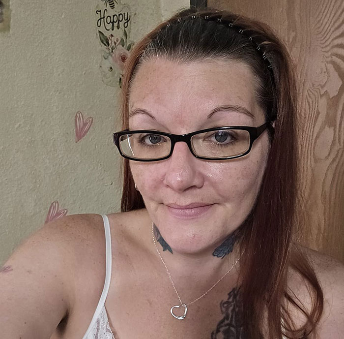 Woman in glasses and a tank top sitting in a room with heart decorations. Woman in glasses and a tank top sitting in a room with heart decorations.