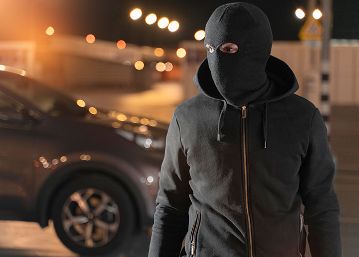 A masked person in a dark street, highlighting the atmosphere of the scariest cities.