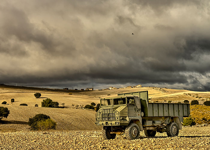 A military truck on a deserted landscape under ominous skies, evoking one of the scariest cities atmosphere.