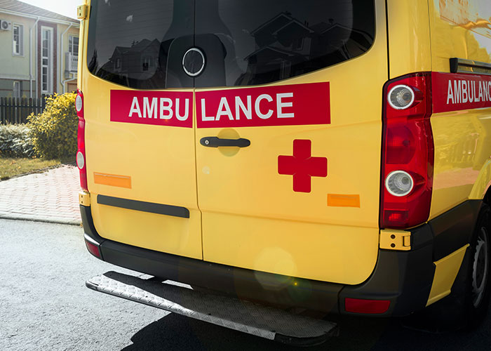 Yellow ambulance with red cross in one of the scariest cities.