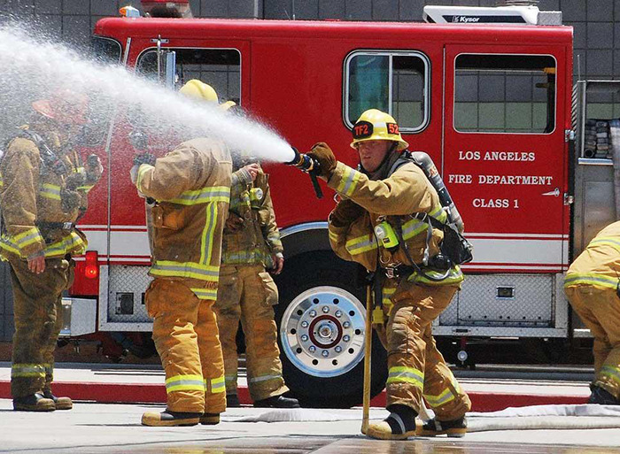Firefighters in action with a Los Angeles fire truck.