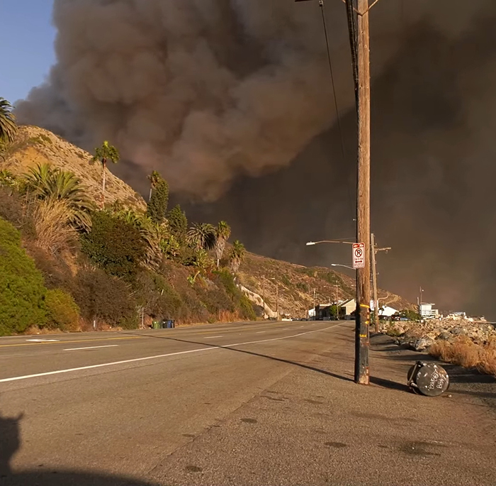 Road with thick smoke from LA wildfires, highlighting impact as celebrities face criticism. Road with thick smoke from LA wildfires, highlighting impact as celebrities face criticism.
