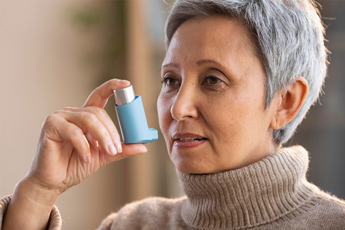 Older woman holding an inhaler, demonstrating a random act that helped her later in a timestamped picture.