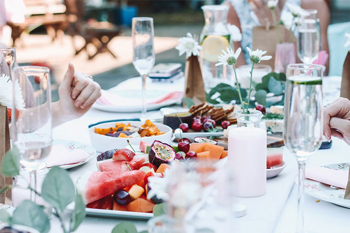 Outdoor table setting with fresh fruit platters and glasses, capturing a moment that really saved people later.