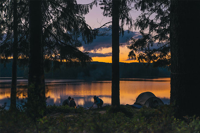 People camping by a lake at sunset, highlighting moments that saved them later in timestamped pictures.