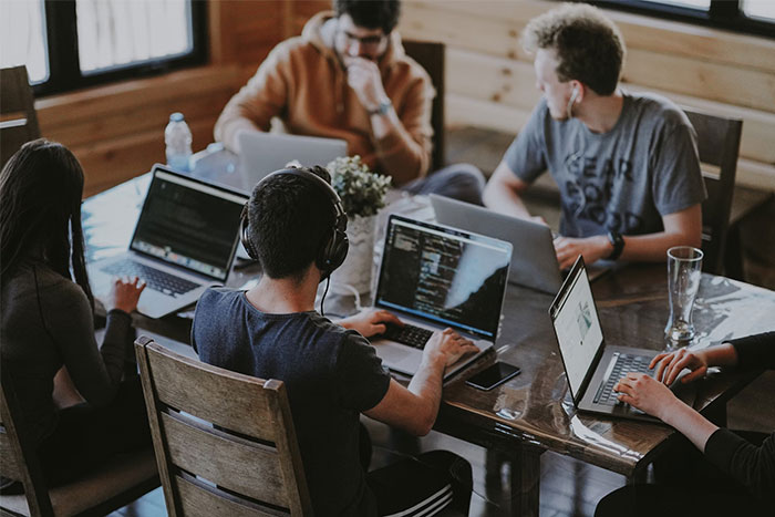 Group of people working on laptops together in a cozy space, illustrating timestamped pictures capturing life-saving moments.
