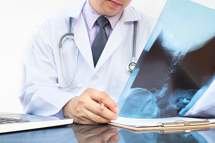 Doctor in white coat reviewing X-ray image and taking notes, illustrating timestamped pictures that saved lives.