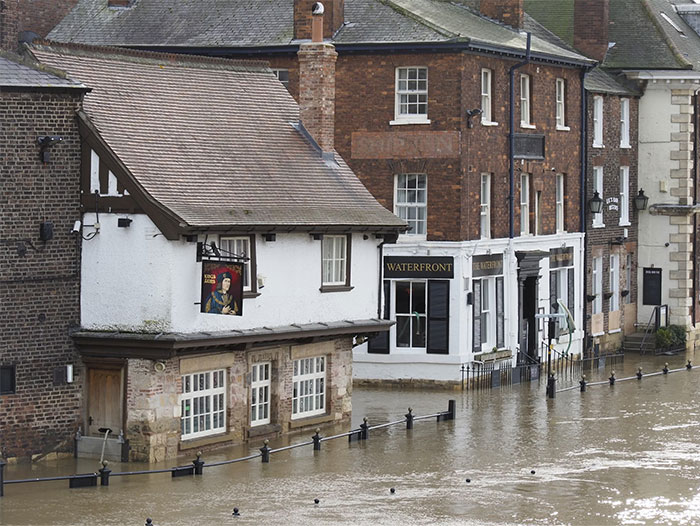 Flooded street with partially submerged historic buildings, illustrating unexpected events that saved people later.