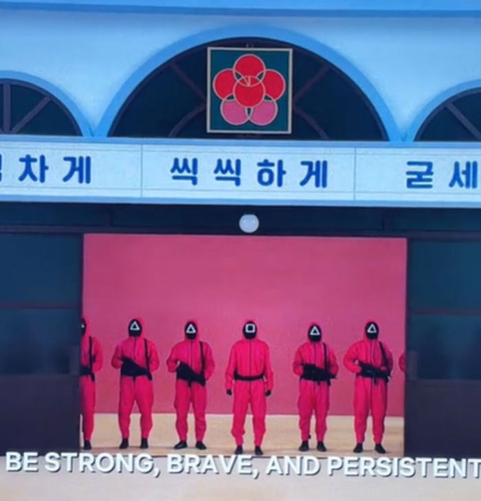 Guards in red suits stand in a line, showcasing Squid Game 2 Easter eggs and clues.