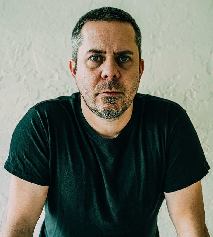 Man in black shirt looking serious, related to dark secrets confessed while drunk.